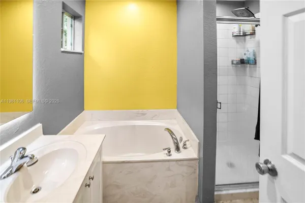 a bathroom with a tub sink and mirror