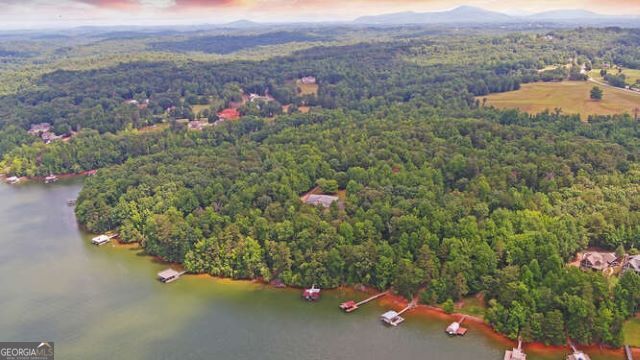 an aerial view of a house with a yard and mountain view in back