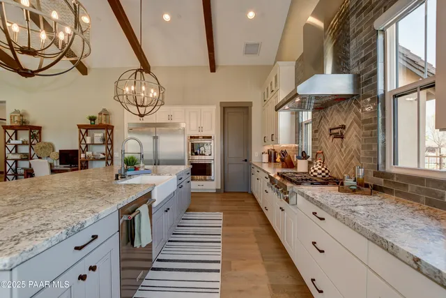 a large kitchen with stainless steel appliances lots of counter space and wooden floor