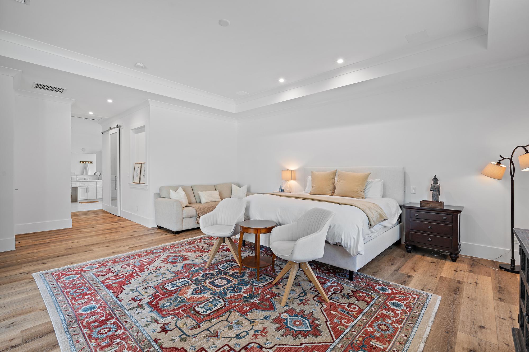 19993 Loxahatchee Pointe Drive Jupiter, FL 33458 - Photo 14 of 42 a spacious bedroom with a bed and wooden floor