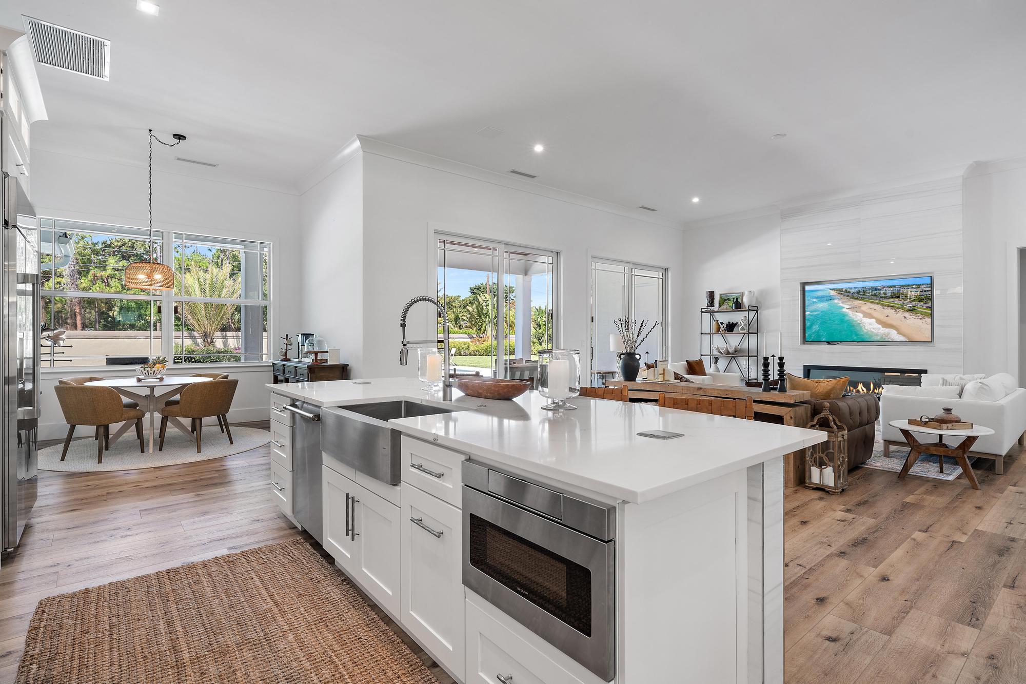 19993 Loxahatchee Pointe Drive Jupiter, FL 33458 - Photo 7 of 42 a open kitchen with stainless steel appliances granite countertop a stove top oven a sink a dining table and chairs with wooden floor