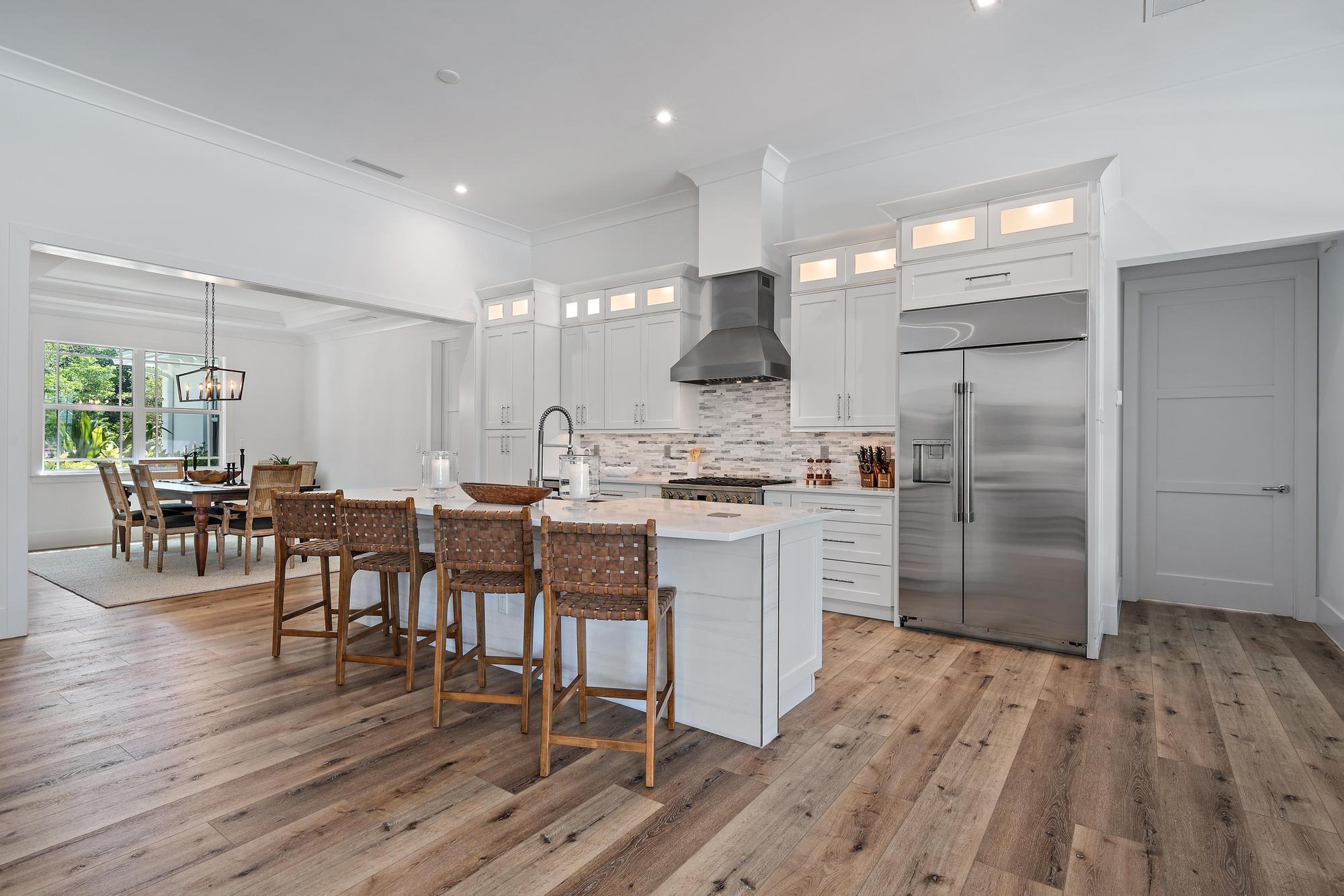 19993 Loxahatchee Pointe Drive Jupiter, FL 33458 - Photo 8 of 42 a kitchen with a table chairs refrigerator and cabinets