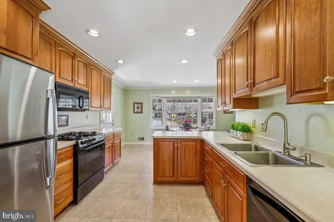 a kitchen with stainless steel appliances granite countertop a sink a stove and a refrigerator
