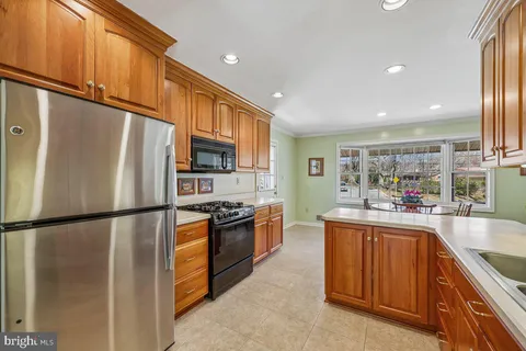 a kitchen with stainless steel appliances granite countertop a refrigerator a stove a sink and a refrigerator