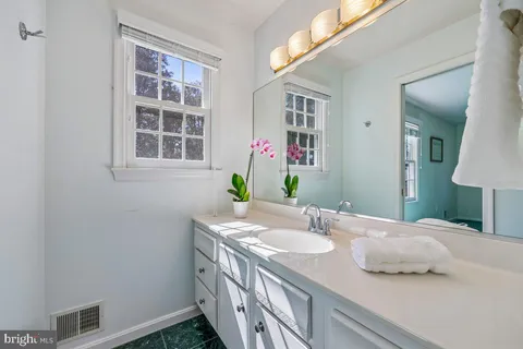 a bathroom with a granite countertop sink a shower and a mirror