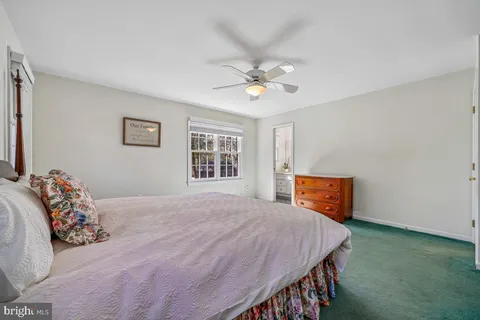 a bedroom with a bed chandelier and a window