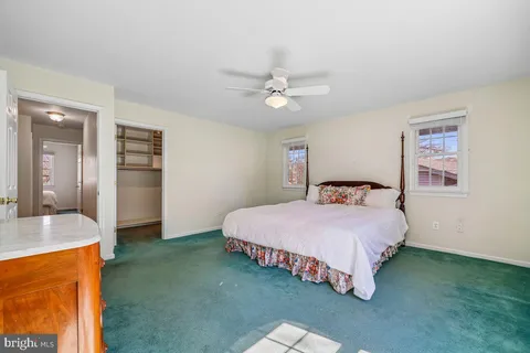 a bedroom with a bed chandelier and a window