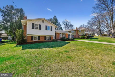 a view of a house with a big yard and large trees