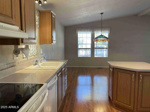 a kitchen with a sink cabinets and wooden floor