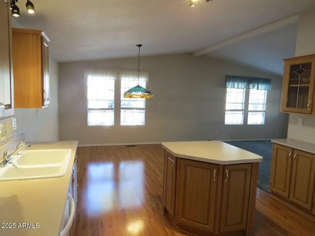 a kitchen with a sink a window and cabinets