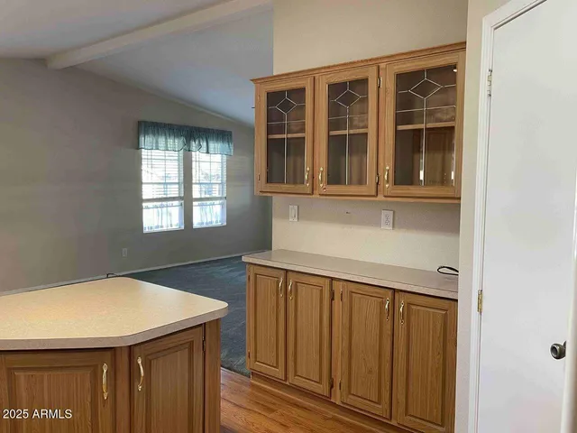 an empty room with wooden floor chandelier fan and windows