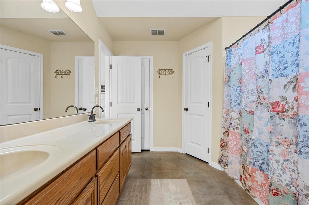 900 Elizabeth Drive Robinson, TX 76706 - Photo 16 of 35 a spacious bathroom with a sink a mirror a shower and a bathtub