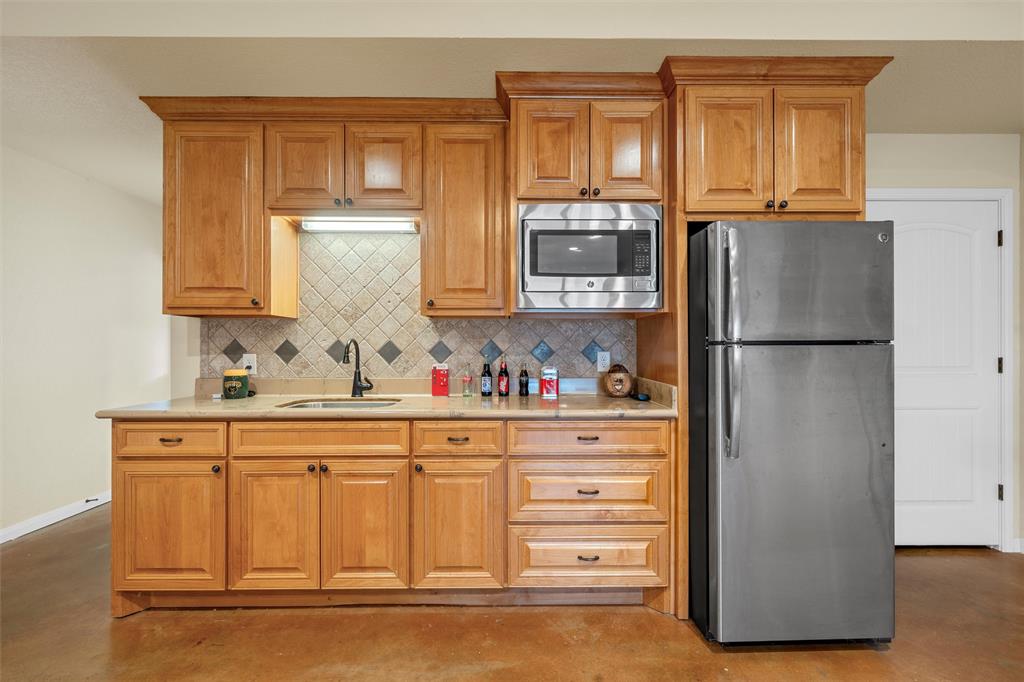 900 Elizabeth Drive Robinson, TX 76706 - Photo 24 of 35 a kitchen with granite countertop a refrigerator and a sink