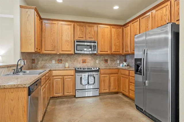a kitchen with stainless steel appliances granite countertop a refrigerator stove and sink
