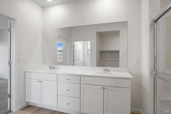 a bathroom with a double vanity sink and mirror