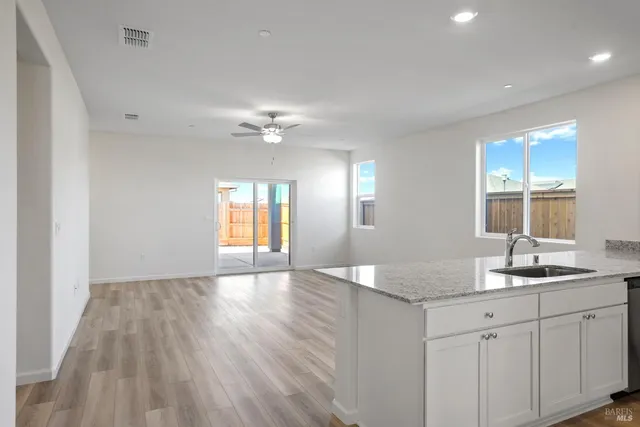 a view of a kitchen sink and dishwasher with wooden floor