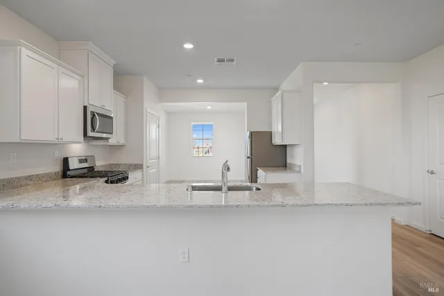 a kitchen with stainless steel appliances granite countertop a sink and a stove top oven