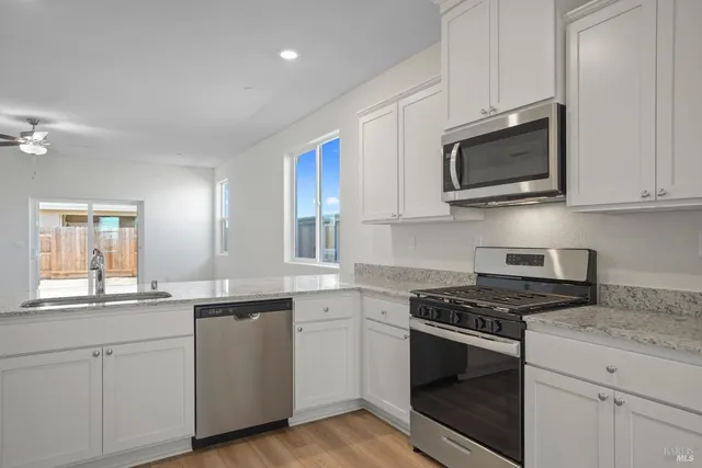 a kitchen with white cabinets stainless steel appliances and sink