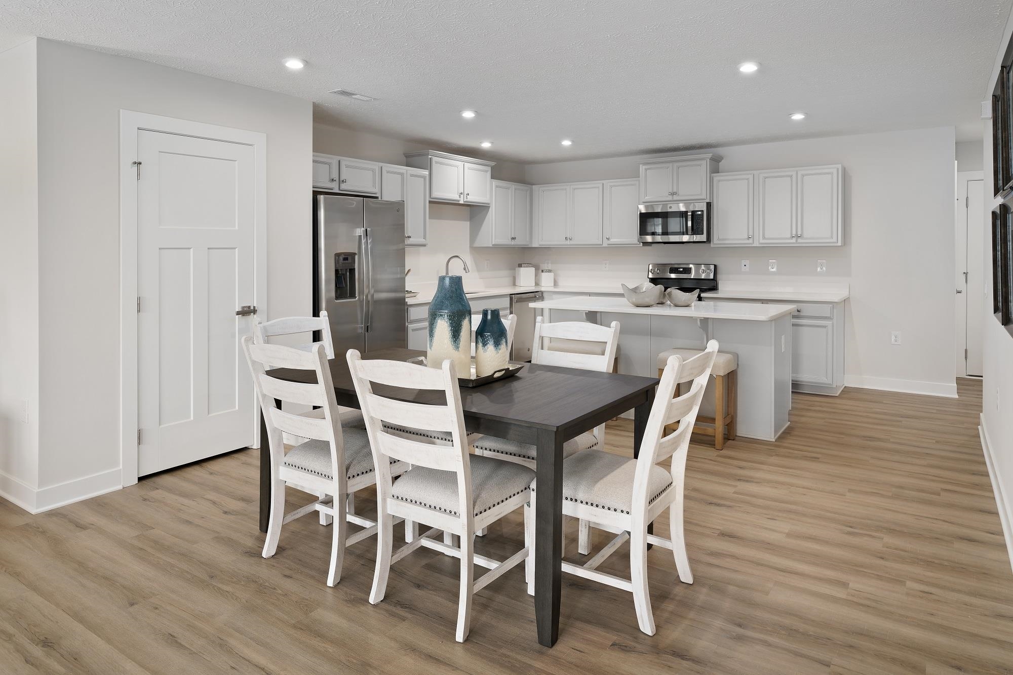 3955 Mayfield Road Mount Crawford, VA 22841 - Photo 6 of 14 a kitchen with a dining table chairs wooden floor cabinets and stainless steel appliances