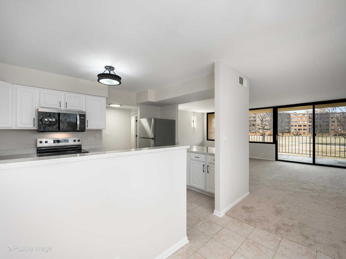 101 Bar Harbour Road, Unit 2M Schaumburg, IL 60193 - Photo 7 of 17 a large white kitchen with stainless steel appliances a large counter top a refrigerator a stove a microwave and cabinets