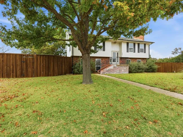 a view of a house with backyard and tree