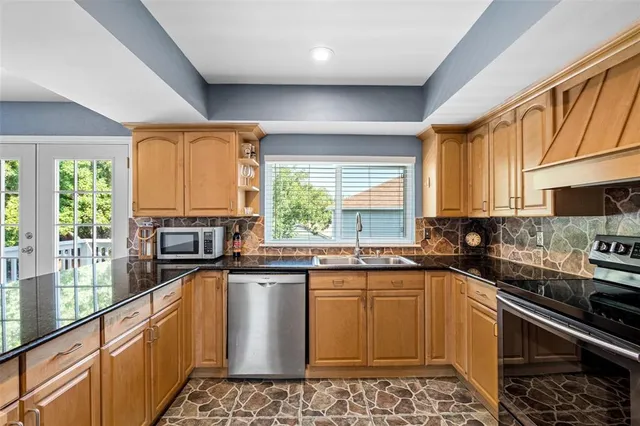 a kitchen with stainless steel appliances granite countertop a stove a sink and a microwave