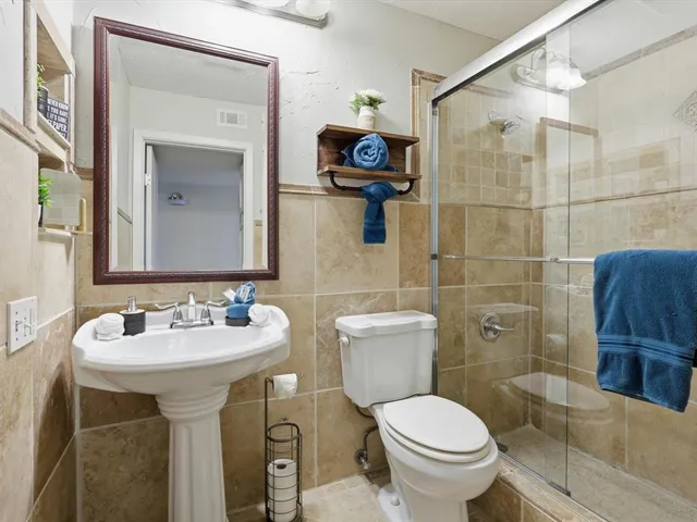 a bathroom with a toilet sink and mirror