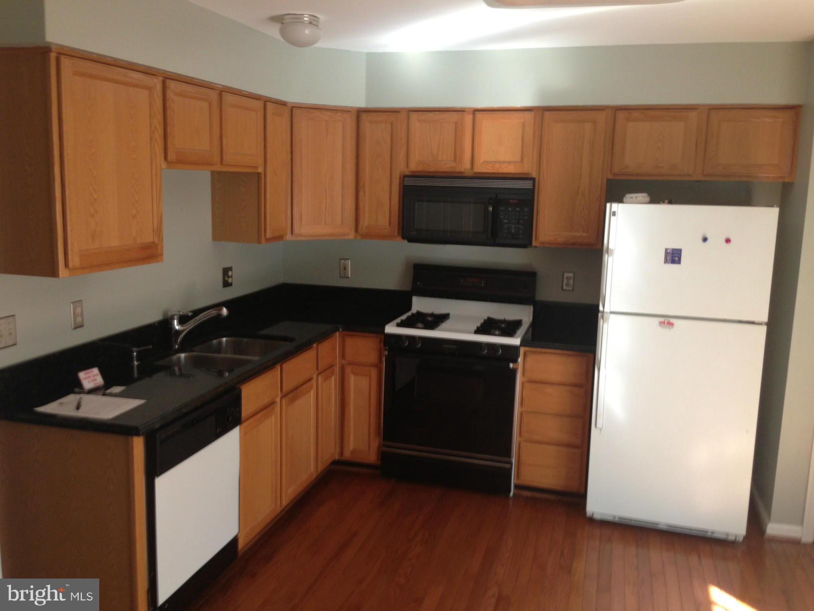 2180 South Glebe Road Arlington, VA 22204 - Photo 4 of 19 a kitchen with a refrigerator stove and wooden cabinets