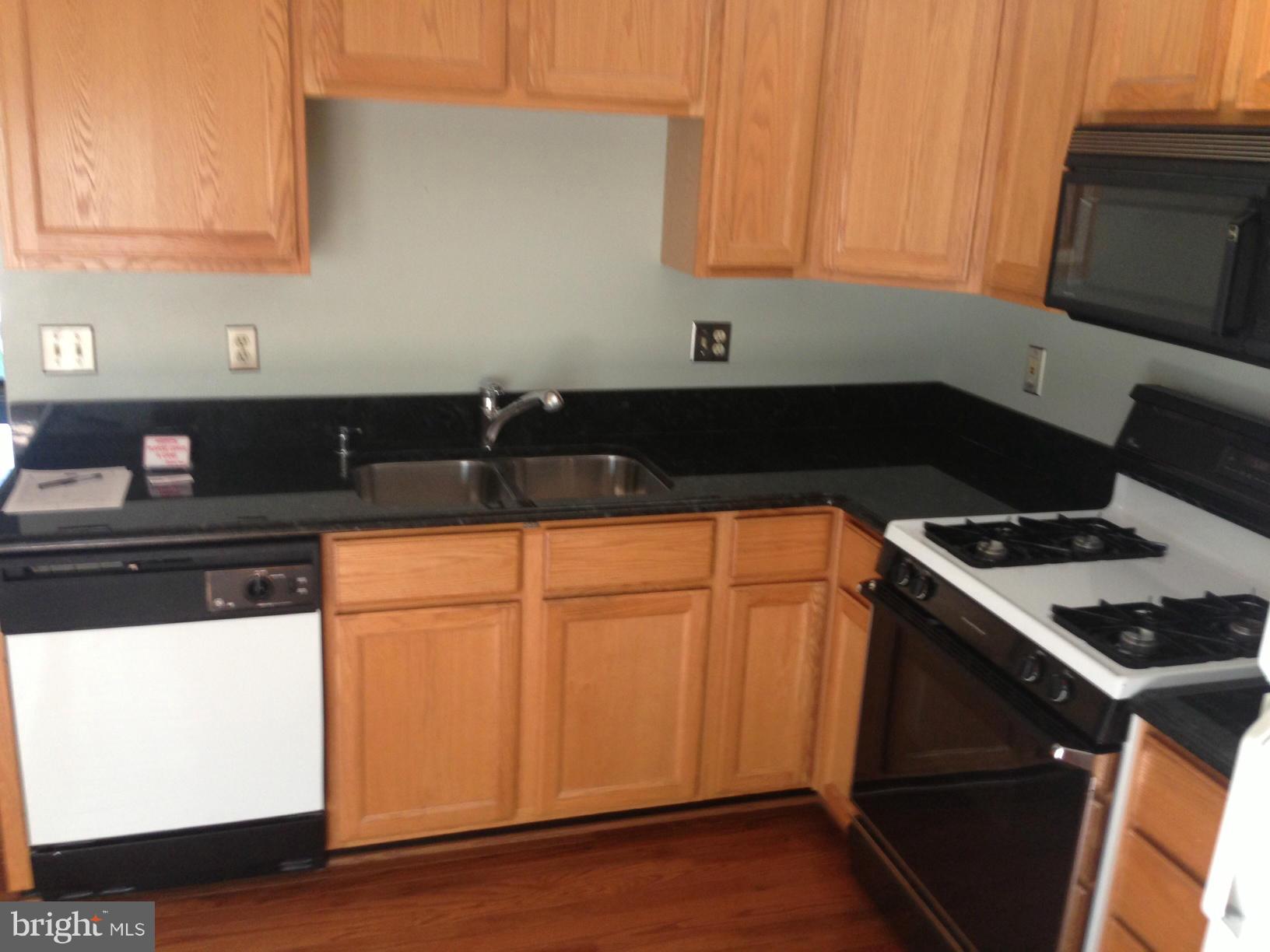 2180 South Glebe Road Arlington, VA 22204 - Photo 5 of 19 a kitchen with granite countertop cabinets and black appliances