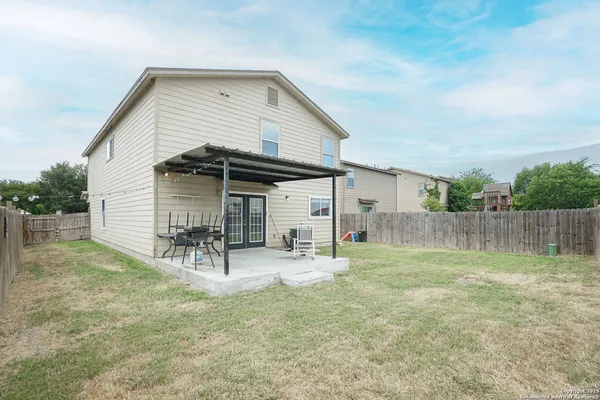 a backyard of a house with table and chairs