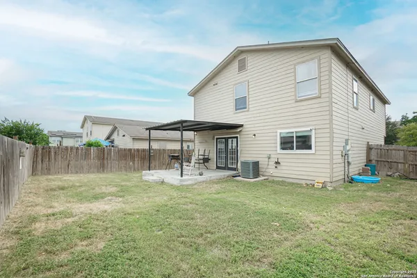 a backyard of a house with table and chairs