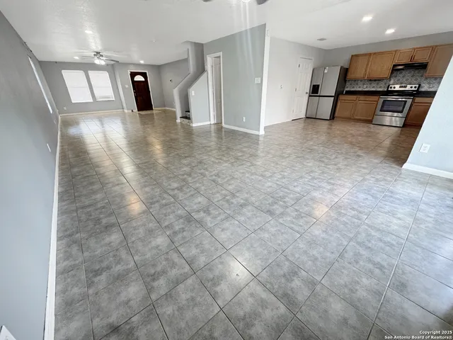a view of a refrigerator in kitchen and a window