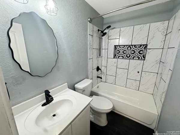 a white toilet sitting next to a shower