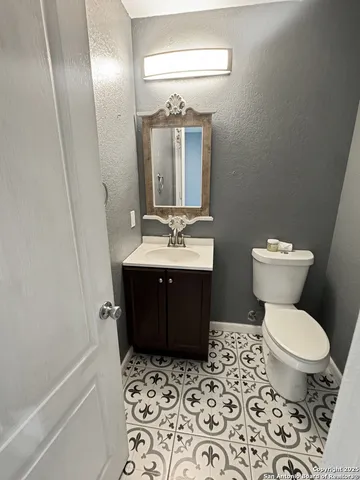 a view of an empty room with a chandelier fan