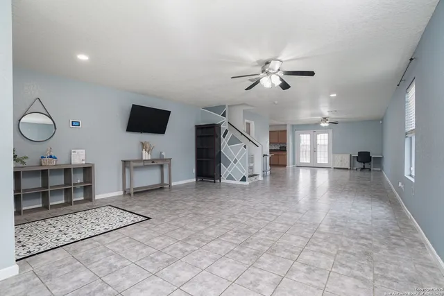 a view of a livingroom with furniture cabinets and a ceiling fan