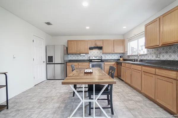 a kitchen with a stove a sink a microwave and cabinets
