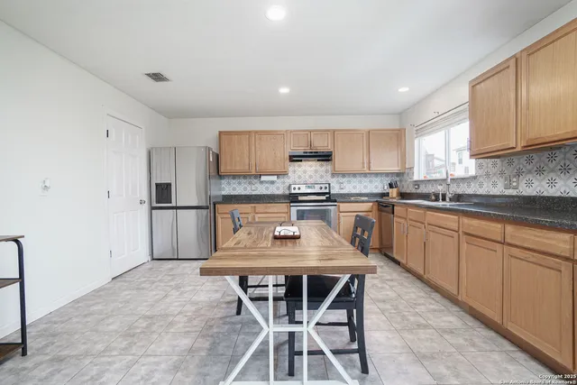 a kitchen with a stove a sink a microwave and cabinets