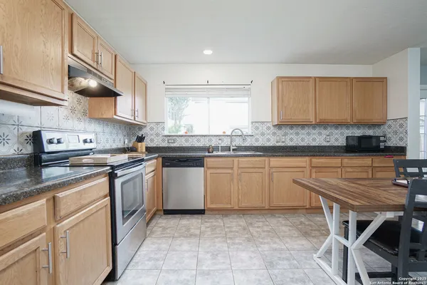 a kitchen with a sink window and cabinets