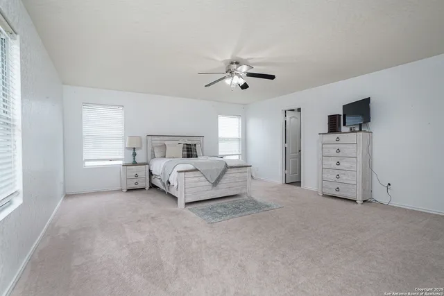 a spacious bedroom with a bed and a chandelier
