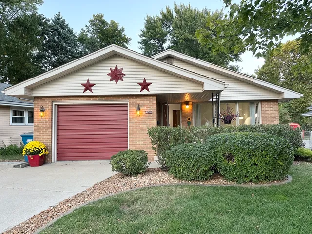 a view of a house with a yard and potted plants