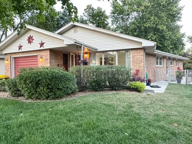 a view of a house with a yard and large tree