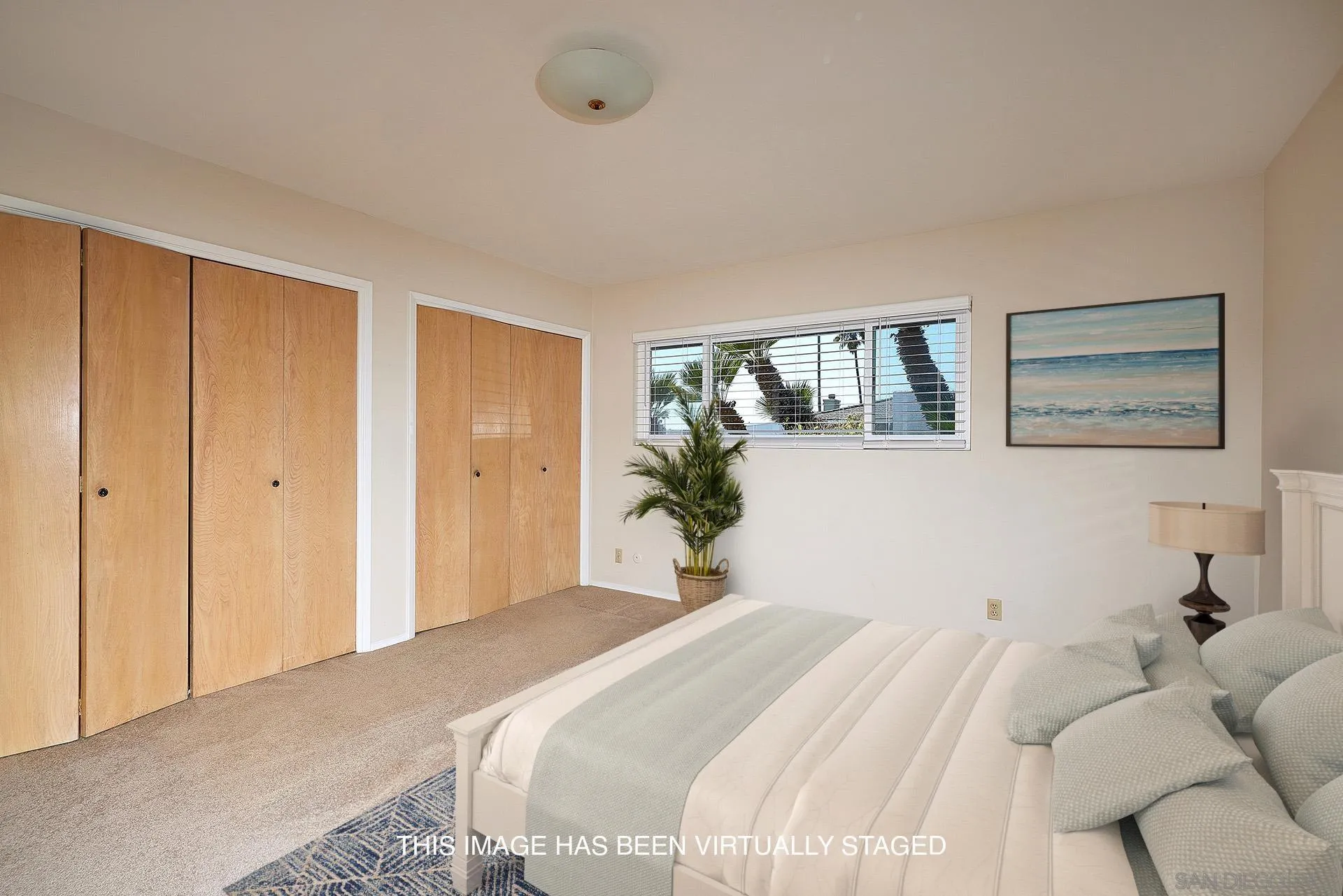 5560 Moonlight Lane La Jolla, CA 92037 - Photo 27 of 48 a bedroom with a large bed and a chandelier