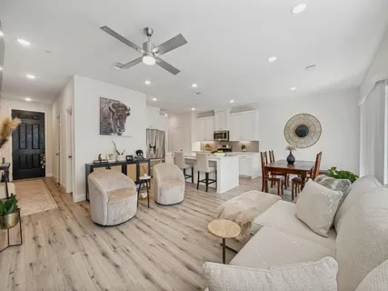 a living room with furniture and kitchen view