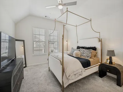 a bedroom with a bed window and a flat screen tv