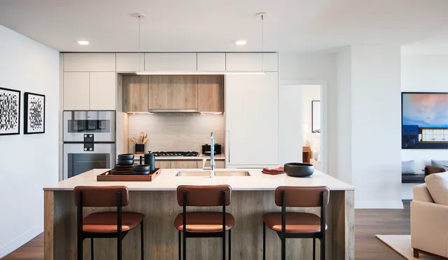 a kitchen with a dining table chairs and white cabinets