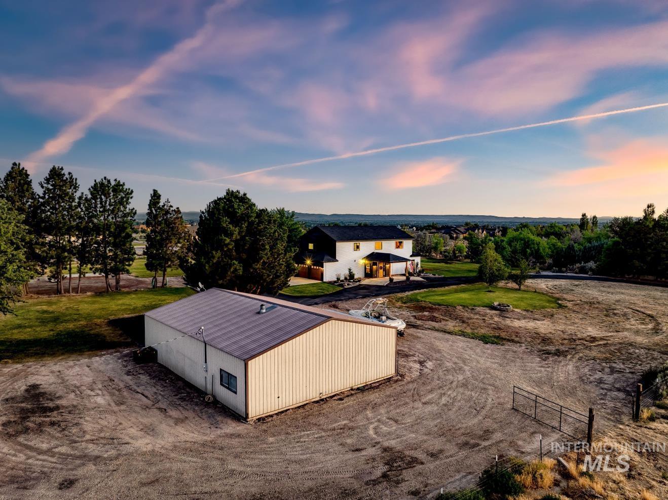 8365 Rustin Road Middleton, ID 83644 - Photo 44 of 48 Aerial view at dusk of the shop & rv parking area of property as well as front pasture.
