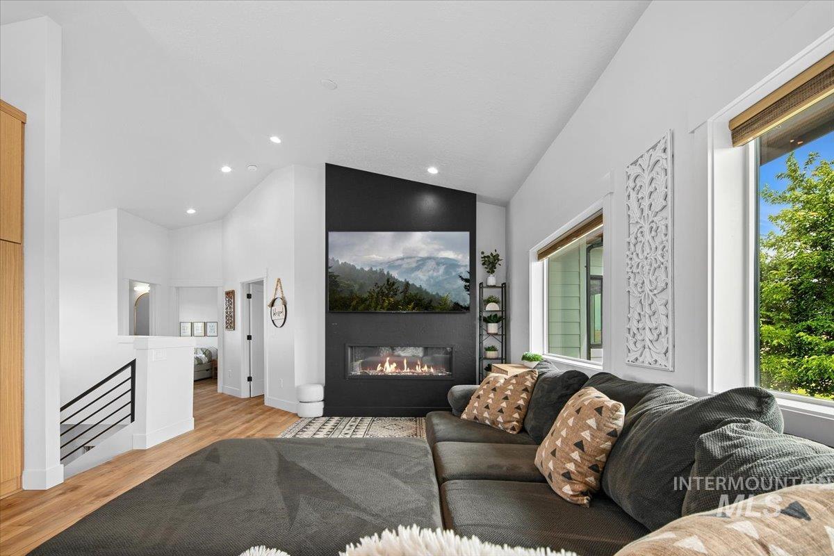 8365 Rustin Road Middleton, ID 83644 - Photo 7 of 48 Living area with wood finished floors, a glass covered fireplace, recessed lighting, and high vaulted ceiling