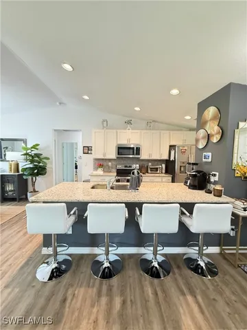 a living room with couches and kitchen view with wooden floor