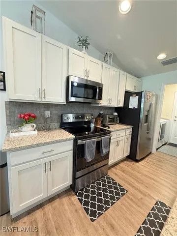 a kitchen with stainless steel appliances a stove a sink a microwave and cabinets