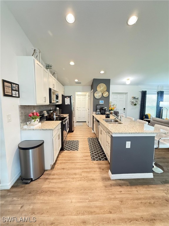 3006 Base Court LaBelle, FL 33935 - Photo 10 of 19 a large room with kitchen island a sink a counter top space and stainless steel appliances
